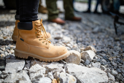 Student in Timberland Boots stands on gravel at jobsite.
